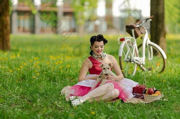 女孩粉红色的衣服发型风格销坐在草野餐草坪上公园阳光明媚的一天复古的风格<strong>照</strong>片