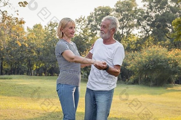 高级夫妻跳舞草坪上公园概念健康的高级夫妻