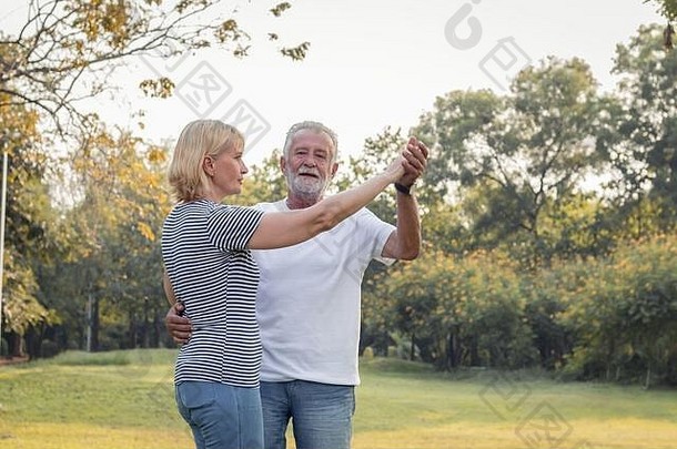 高级夫妻跳舞草坪上公园概念健康的高级夫妻