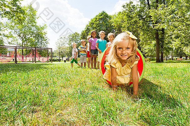 金发碧眼的女孩朋友玩管草坪上