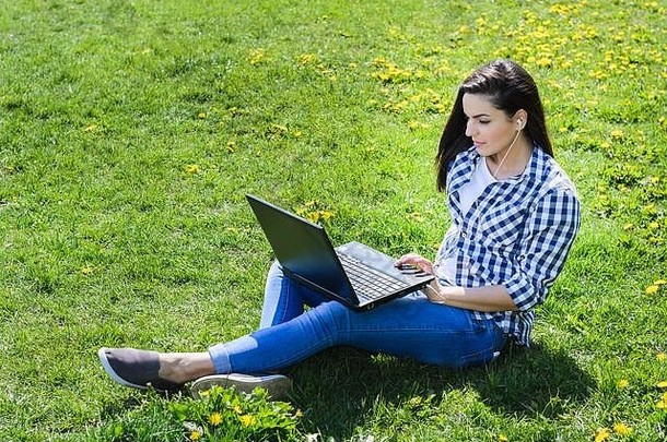 女人休息草坪上移动PC