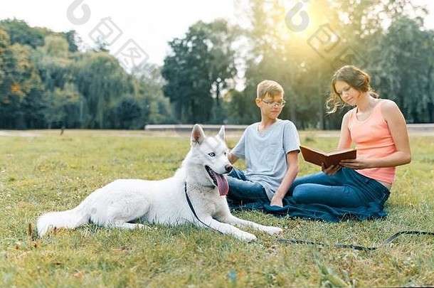 孩子们休息公园绿色草坪上白色狗沙哑的阅读书会说话的