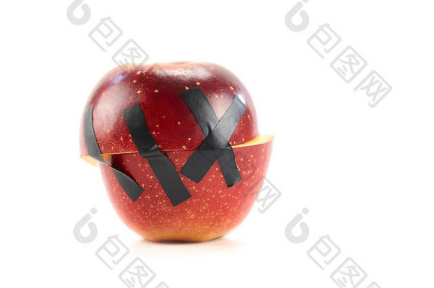 半红色的苹果举行黑色的磁带孤立的白色背景