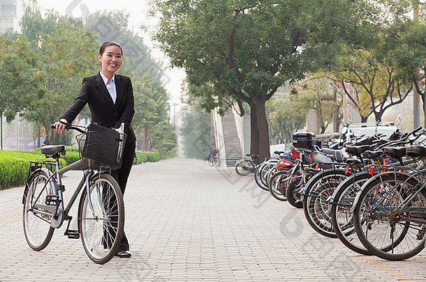 年轻的女商人持有自行车人行道<strong>上</strong>北京