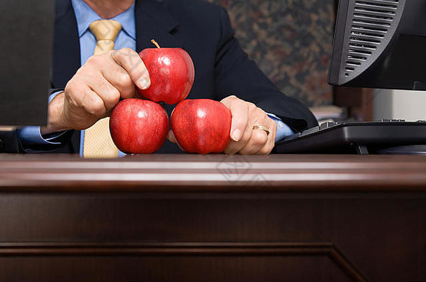 商人平衡苹果桌子上