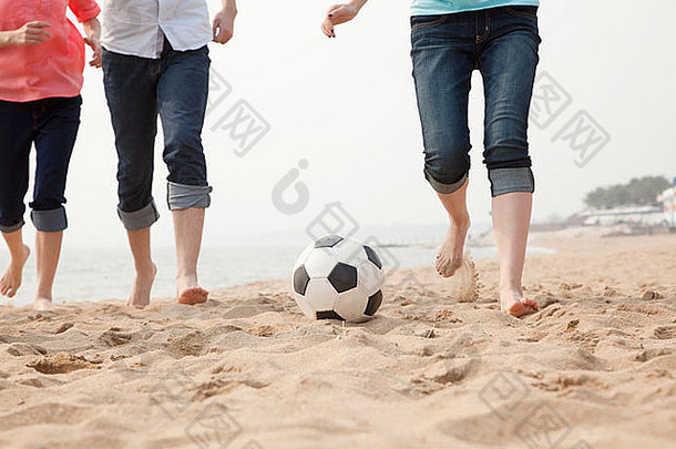 年轻的朋友玩足球海滩