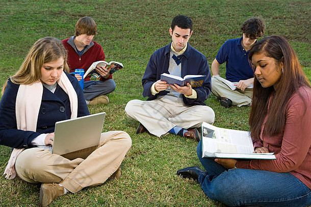 学生坐阅读在户外
