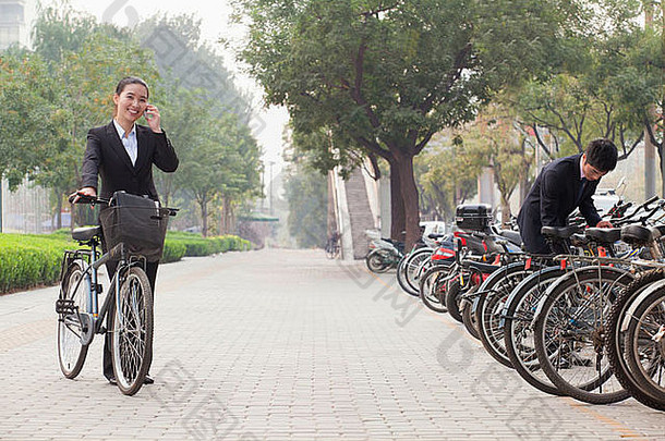 年轻的业务人停车自行车会说话的电话北京