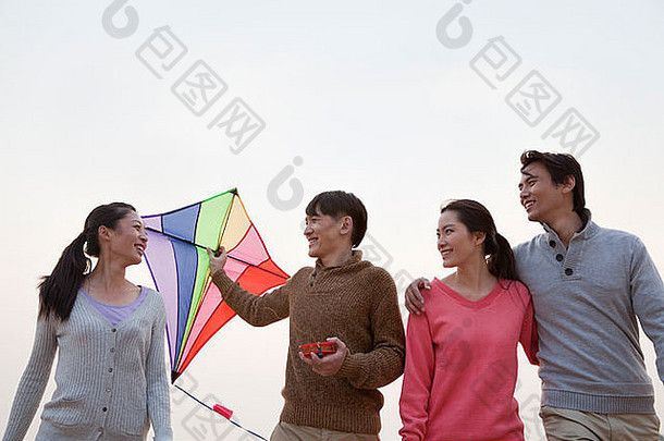 年轻的朋友飞行风筝海滩