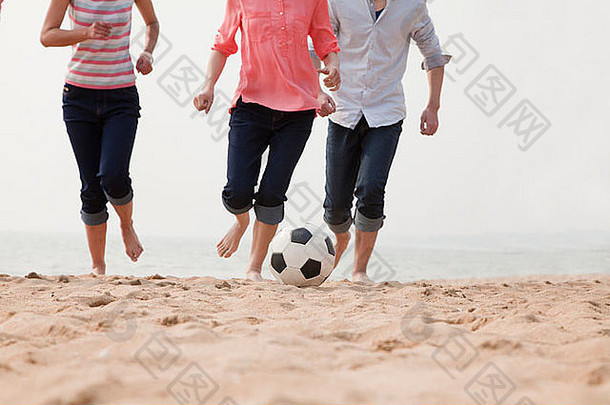 年轻的朋友玩足球海滩