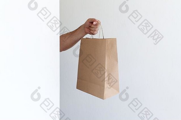 特写镜头男人。持有手棕色（的）清晰的空空白工艺纸袋外卖光灰色的背景包装交付服务概念