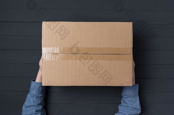 孩子手持有大纸板盒子交付包裹房子前视图