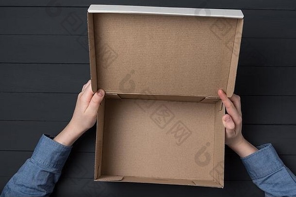 孩子们的手持有开放纸板盒子空盒子黑色的背景
