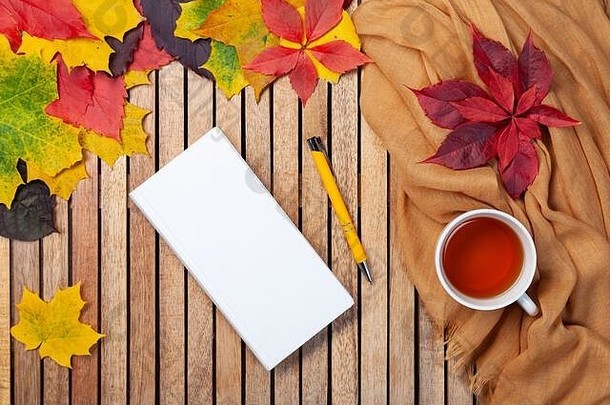 秋天叶子白色笔记本茶杯表格纺织餐巾木背景