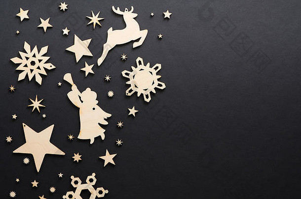 木手工制作的圣诞节装饰黑暗黑色的背景圣诞节雪花鹿天使星星复制空间平躺前视图冬天