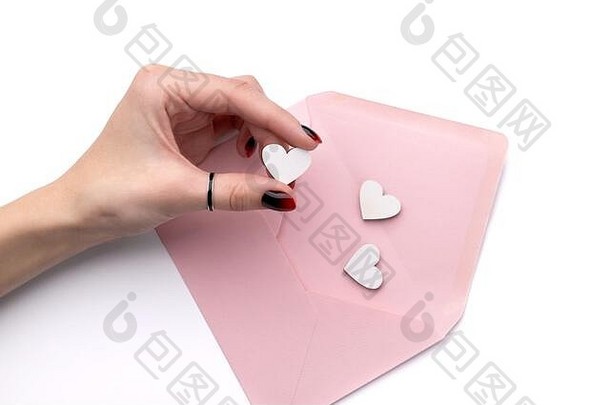 女士手修指甲持有木心粉红色的信封孤立的白色背景有创意的情人节一天浪漫的作文平躺