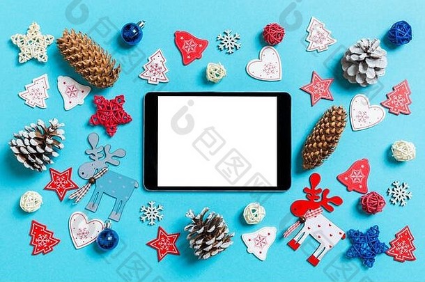 前视图数字平板电脑包围一年玩具装饰蓝色的背景圣诞节时间概念