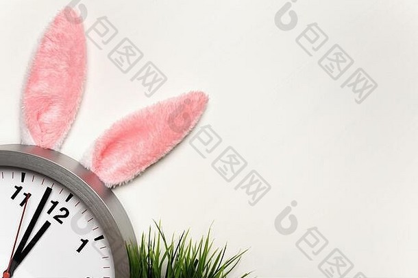 复活节概念时钟兔子耳朵绿色草白色背景复制空间