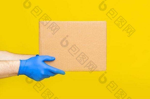 关闭手交付男人。医疗手套持有空纸板盒子黄色的工作室背景服务冠状病毒在线购物模拟