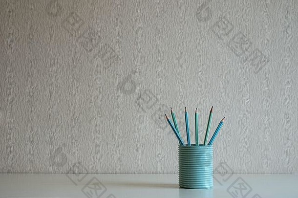 关闭柔和的铅笔蓝色的玻璃桌子上灰色的墙背景