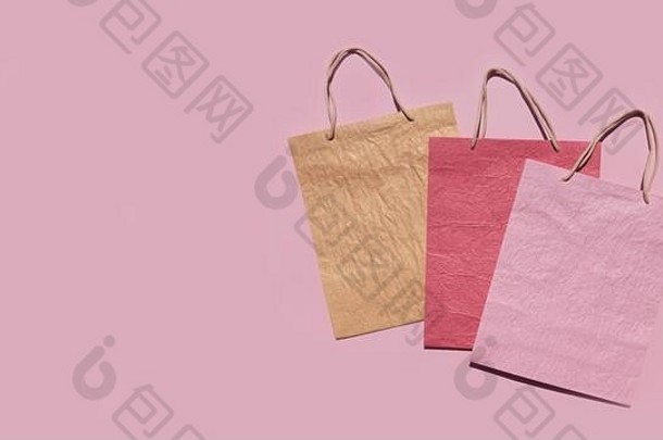色彩鲜艳的变形纸购物袋粉红色的背景最小的时尚购物在线概念复制空间前视图平躺