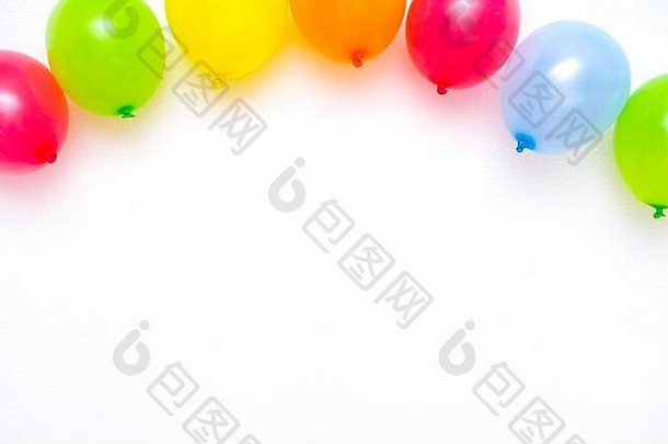 色彩斑斓的气球白色墙表格前视图节日聚会，派对背景平躺风格Copyspace文本生日问候卡