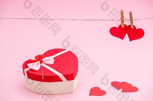 心形状的礼物盒子红色的纸心粉红色的柔和的背景衣服挂钩红色的纸心绳子情人节一天概念