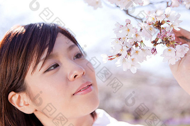 年轻的女人樱桃花朵