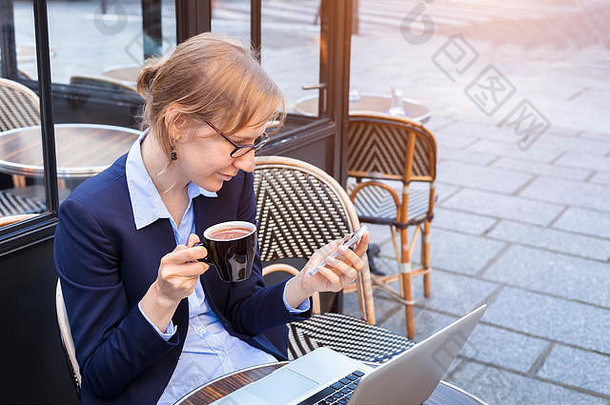 年轻的快乐业务女人智能手机移动PC午餐阳台