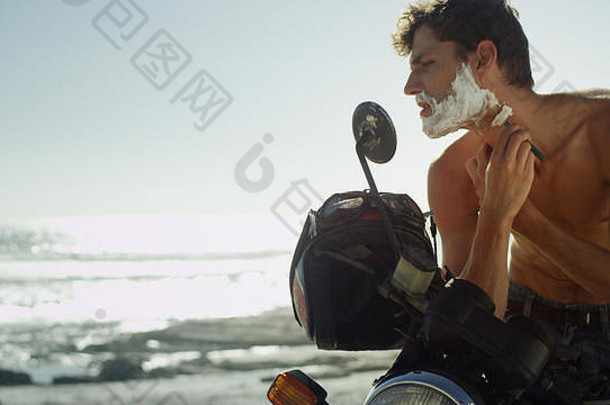 年轻的男人。摩托车剃须胡子海洋