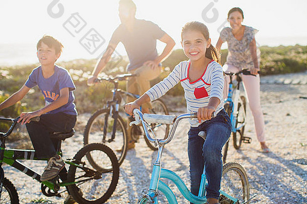 家庭骑自行车阳光明媚的海滩