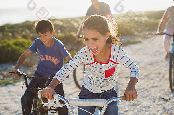 家庭骑自行车阳光明媚的海滩