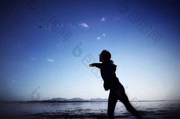 年轻的女孩<strong>扔石头</strong>海安格尔西岛威尔士