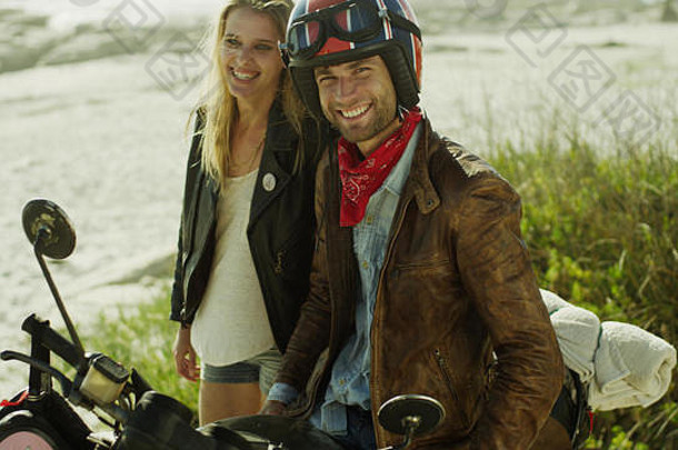 肖像微笑年轻的夫妇摩托车海滩