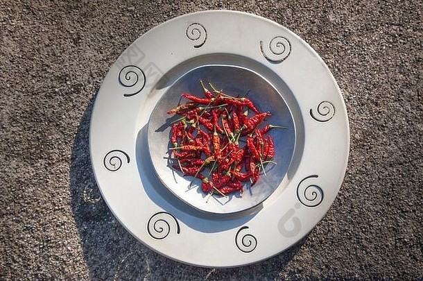 照片红色的热辣椒金属盘子卵石结构化背景