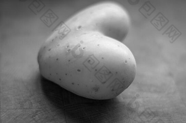 孤立的关闭单心形状的生土豆黑色的白色