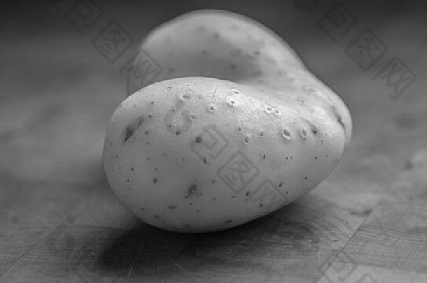 孤立的关闭单心形状的生土豆黑色的白色