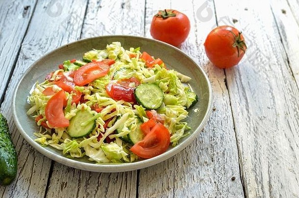 蔬菜沙拉灰色的板木光背景免费的空间文本沙拉黄瓜番茄卷心菜