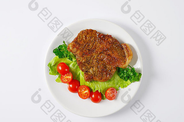 片烤猪肉肉蔬菜装饰白色板