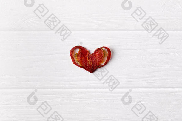 脆脆脆的有机番茄芯片心形状白色木背景