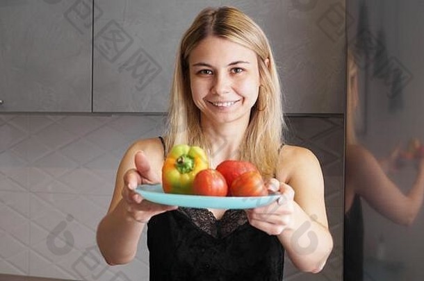 女人持有板新鲜的蔬菜微笑背景厨房