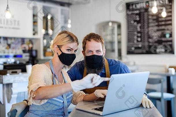 咖啡商店主人脸面具封锁检疫冠状病毒回来正常的概念