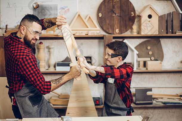 家庭关系为父之道爱好木工木制品概念父亲儿子玩骑士木Diy剑卡彭特车间