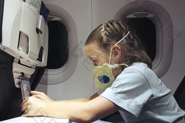 女孩高加索人飞机穿保护面具孩子婴儿旅游飞机呼吸器玩智能手机移动科维德