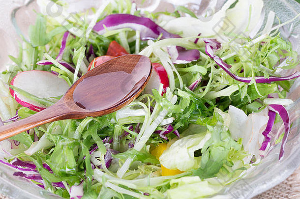 倒橄榄石油沙拉勺子健康的食物生活方式新鲜的沙拉石油