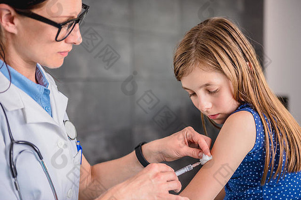 儿科女医生给年轻的女孩疫苗拍摄手臂