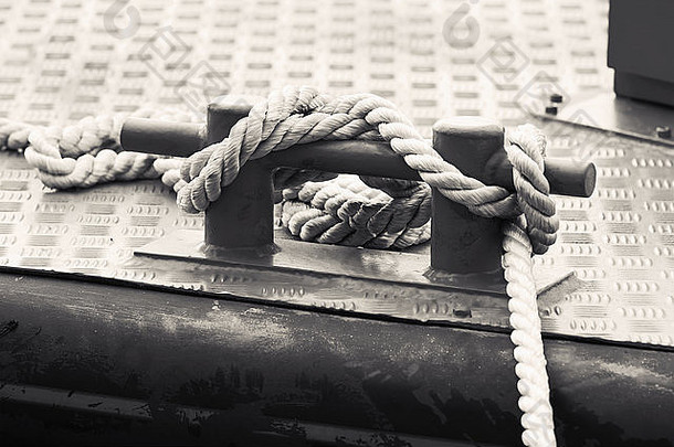 黑色的钢带缆桩绳子安装船甲板单色照片