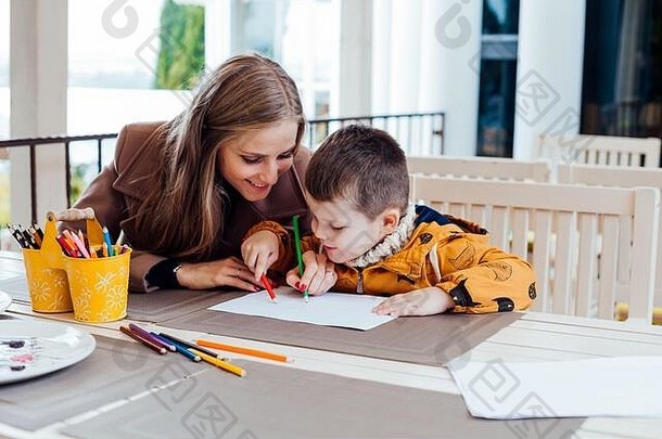 妈妈。儿子画画手彩色的铅笔