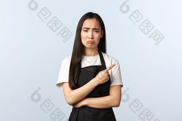 咖啡商店小业务启动概念伤心悲观的失望女咖啡馆老板咖啡师黑色的围裙指出手指