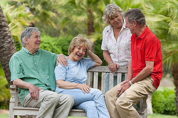 上了年纪的夫妻坐着板凳上花园